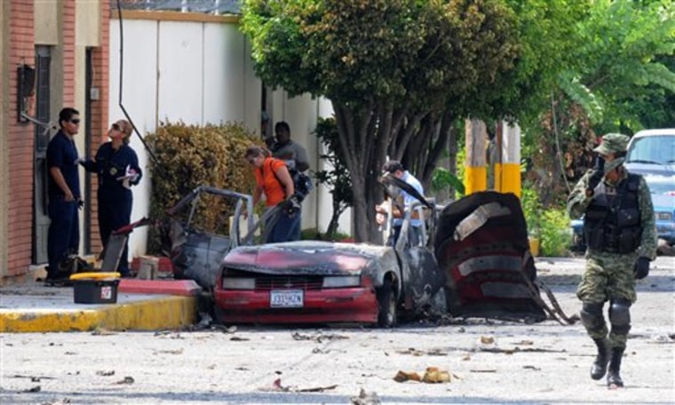 A soldier and investigators work at the site where a vehicle exploded outside the Televisa network in the northern city of Ciudad Victoria, in Mexico, on Friday Aug. 27. 
